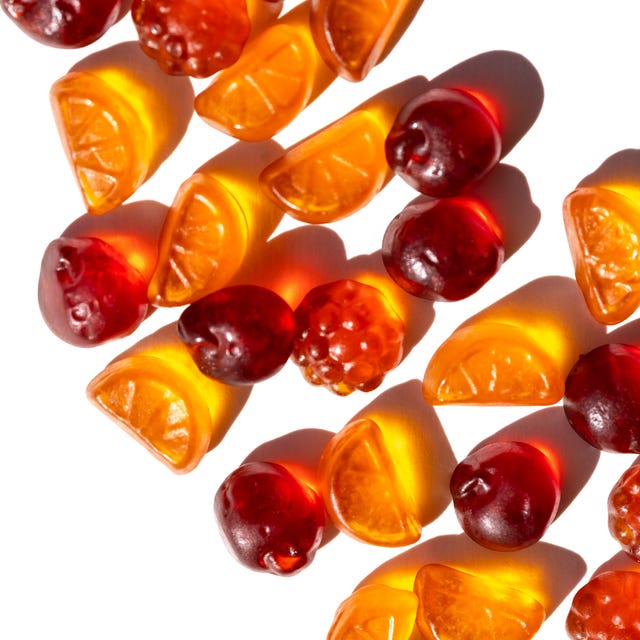 neatly aligned citrus and berry gummies form a dynamic diagonal across bright white selective focus, vitamins and healthy snack for kids promote healthy food, nutrition and healthy life