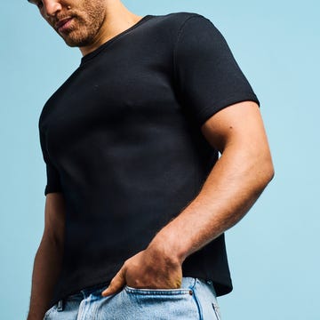 Man posing in casual attire against a light blue background. Man posing in casual attire against a light blue background.