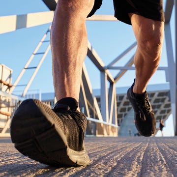 Person jogging on a textured surface near a modern structure.