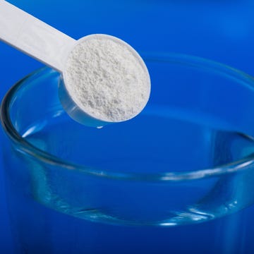 Sport supplement, creatine, hmb, bcaa, amino acid or vitamin - mesure with powder over a glass of water. Sport nutrition concept. sport supplement, creatine,