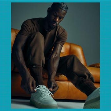 person wearing lightcolored sneakers while sitting on an orange sofa person wearing lightcolored sneakers while sitting on an orange sofa