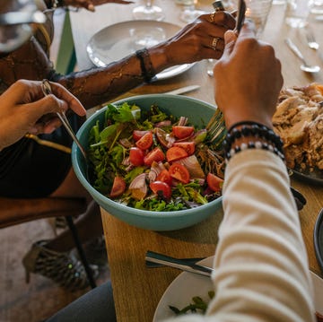 Man Serving Salad From Bowl During Dinner Party man serving salad from bowl during dinner party