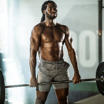 Sweaty African American athletic man exercising with barbell in a gym. sweaty african american athletic man exercising with barbell in a gym