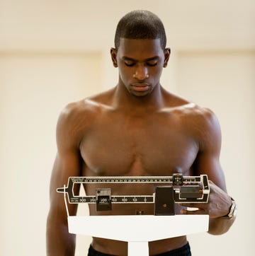 Young man standing on weight scale Young man standing on weight scale